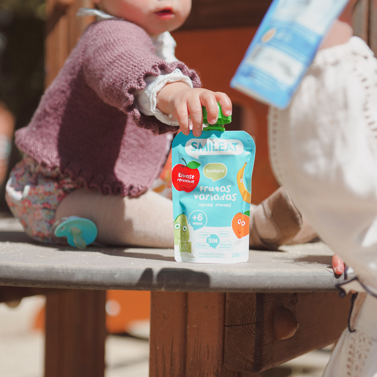 bebé comiendo un pouch de frutas variadas